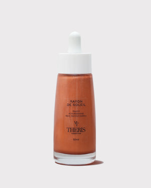 Shimmering Rayon De Soleil Olio Illuminante by Theris, displayed in a sleek bottle with a luminous glow.